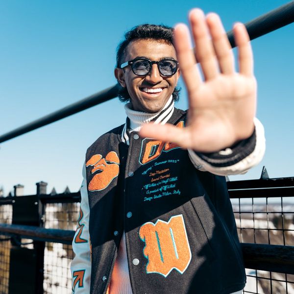 A person stretching in a bright, sunlit room, looking refreshed and energetic.